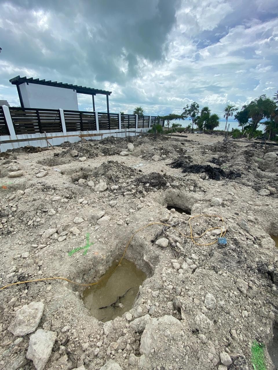 Early groundwork on the filled beachfront lot, with the shell rising beyond